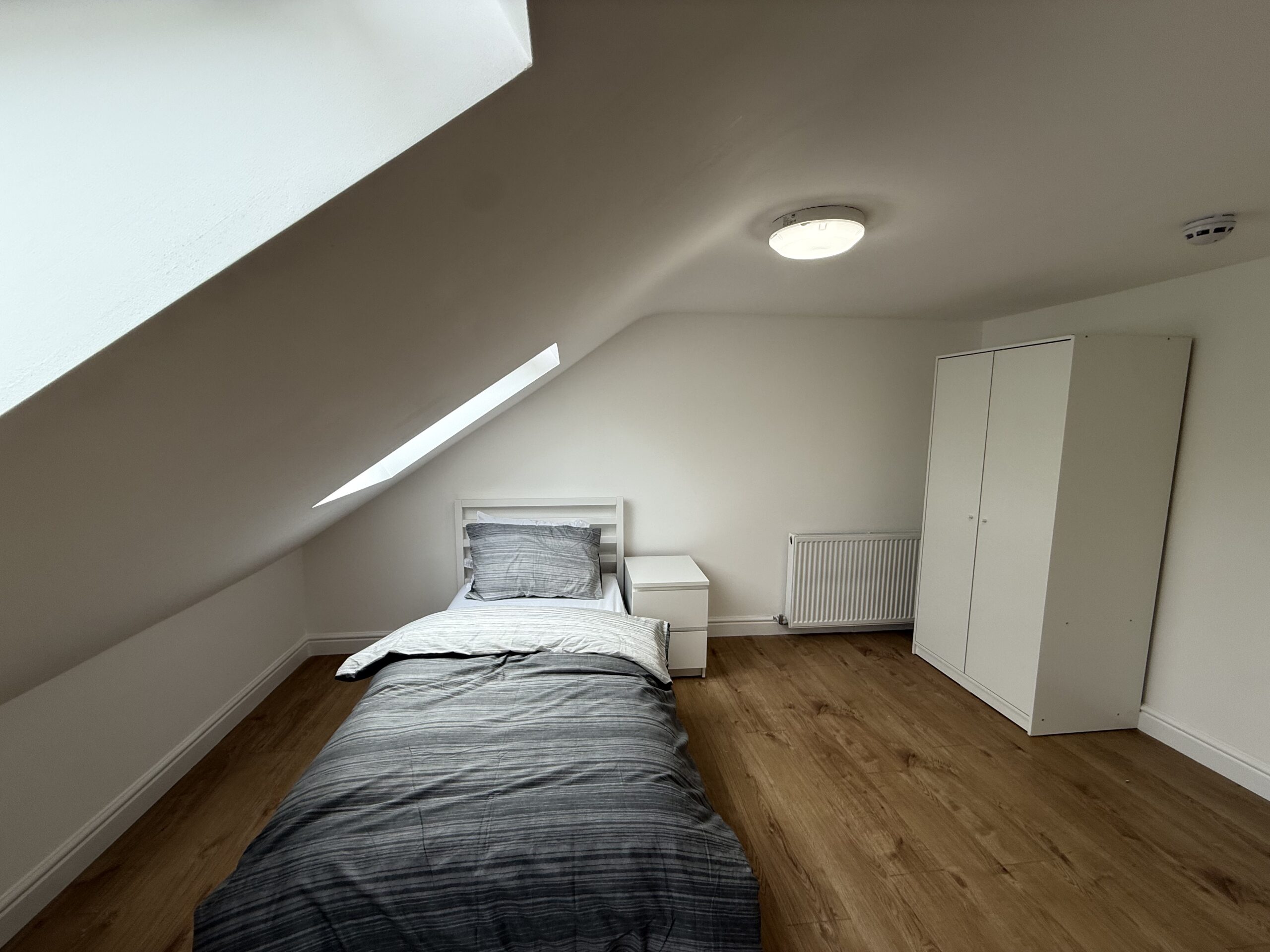Attic Bedroom 5 with slanted ceiling, bed and wardrobe
